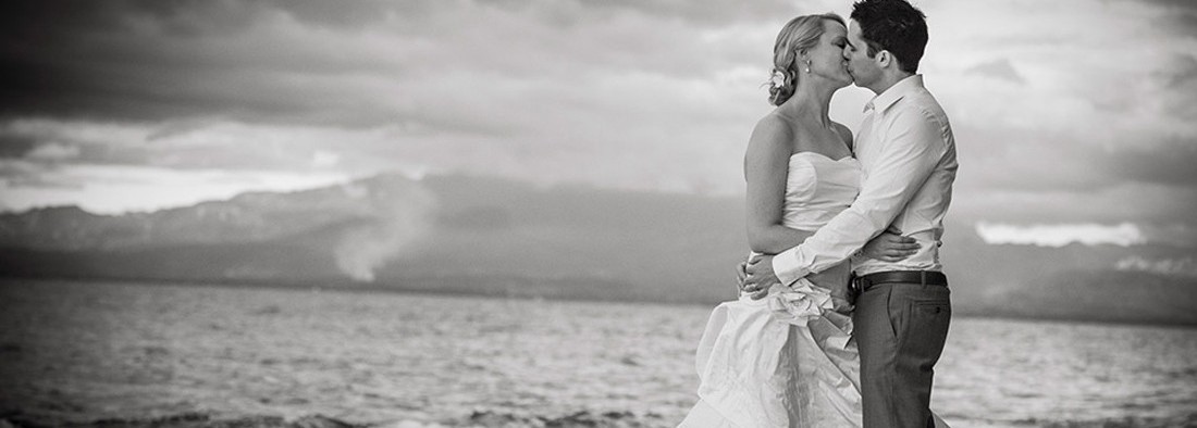 Black and white photo of a bride and groom kissing - Wedding Travel